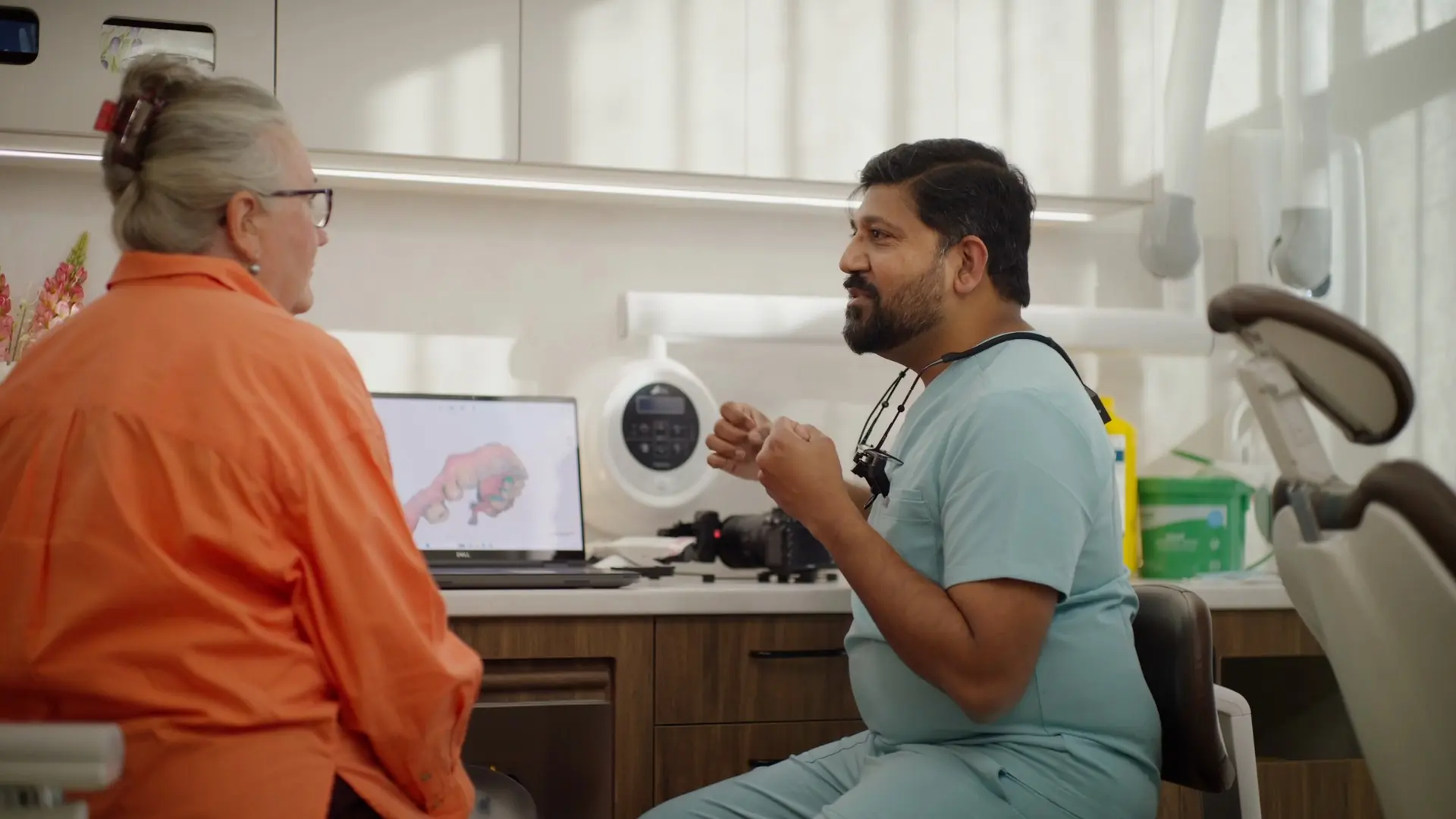 Dr Sri talking with a patient at the consult desk