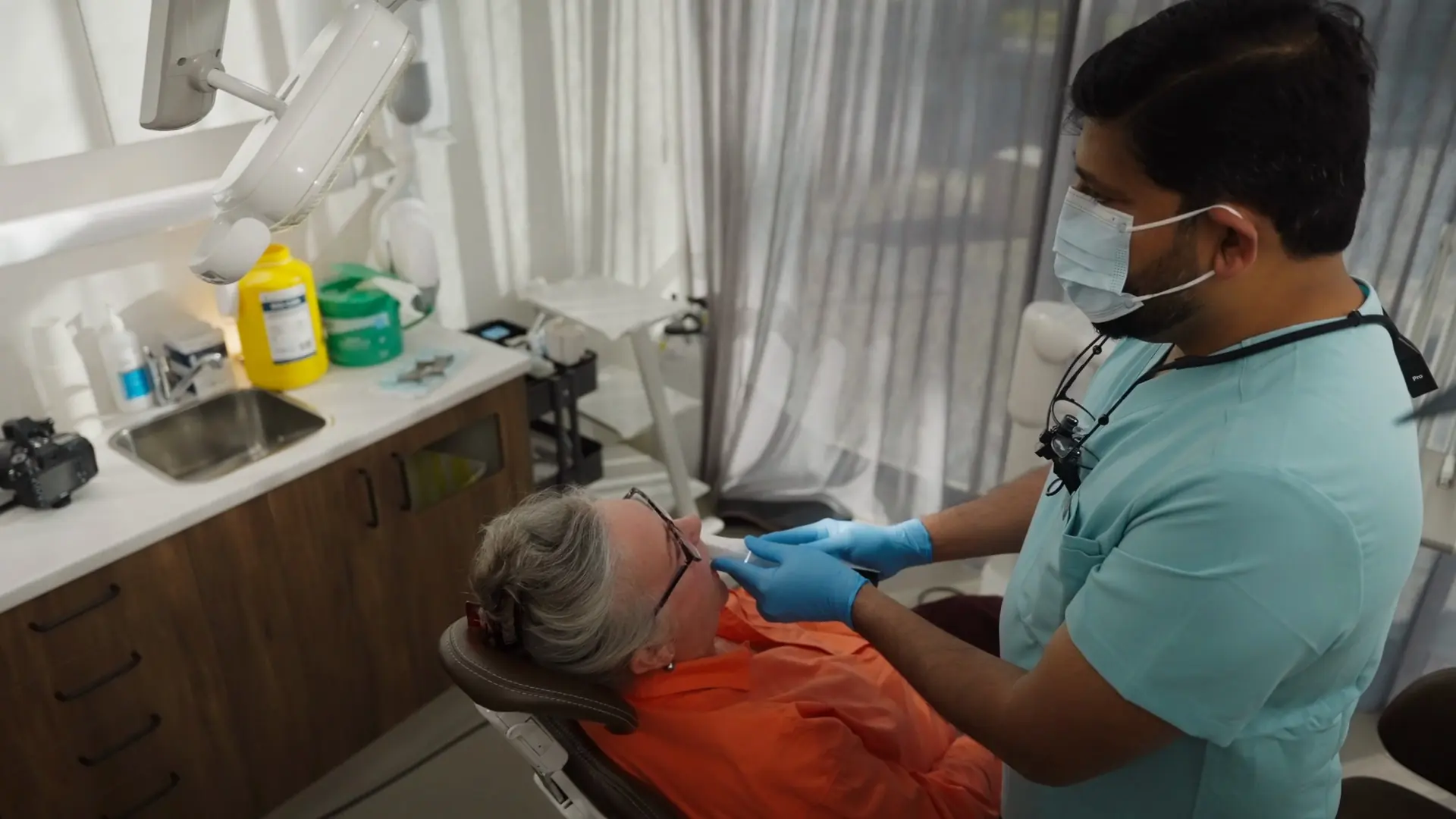 A dentist checking a patient in the dental chair