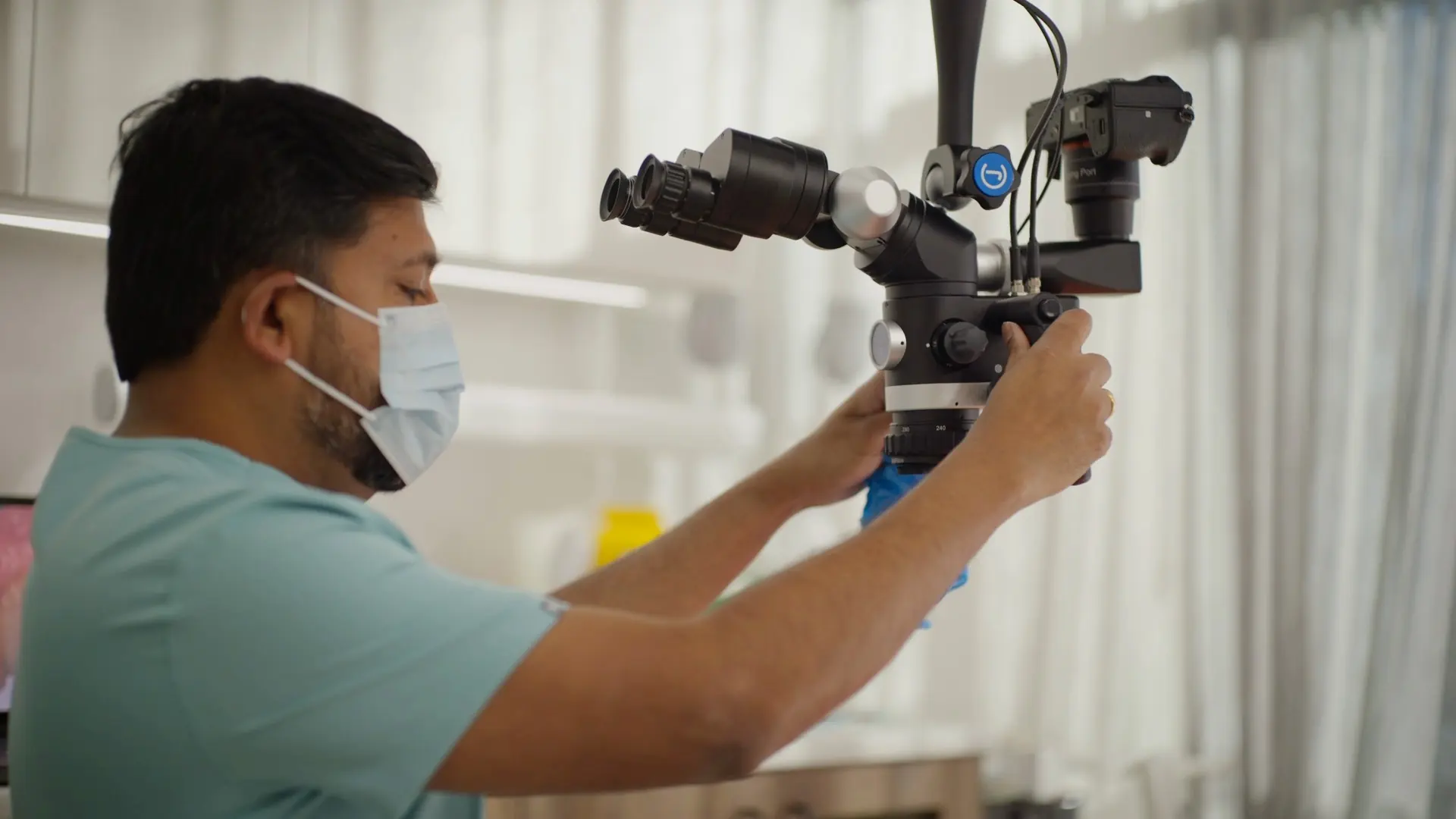 A dentist adjusting the dental microscope before treatment