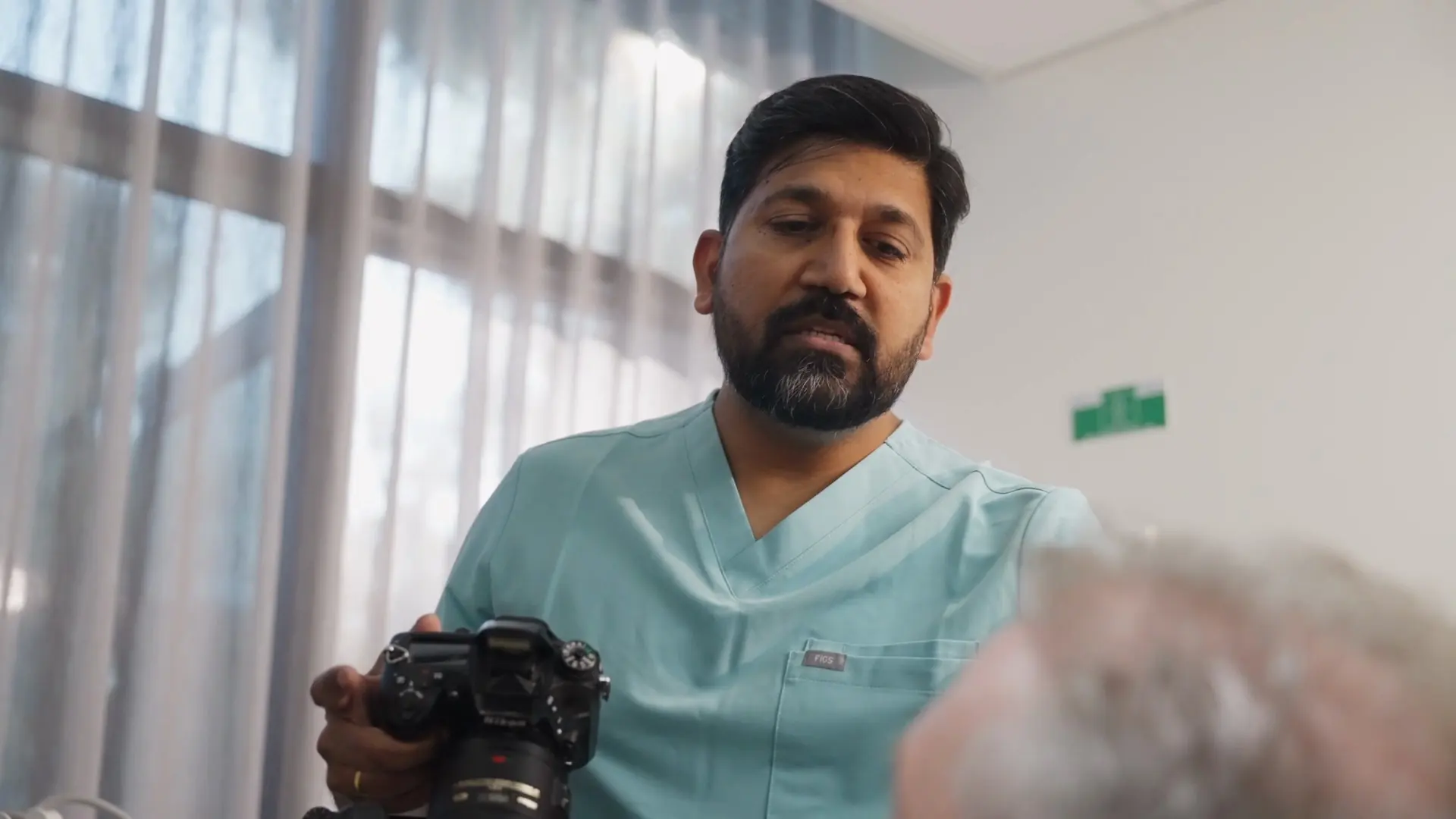 Dr Sri holding a camera for clinical photos